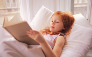 Young girl reading lying down