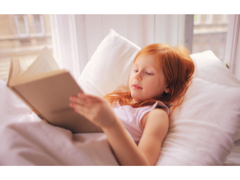 Young girl reading lying down