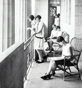 Young women on the porch of a dorm