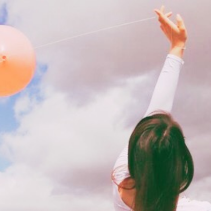 Young Woman releasing a balloon with a secret message