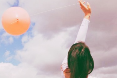 Young Woman releasing a balloon with a secret message