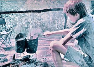 Boy Cooking On A Campfire